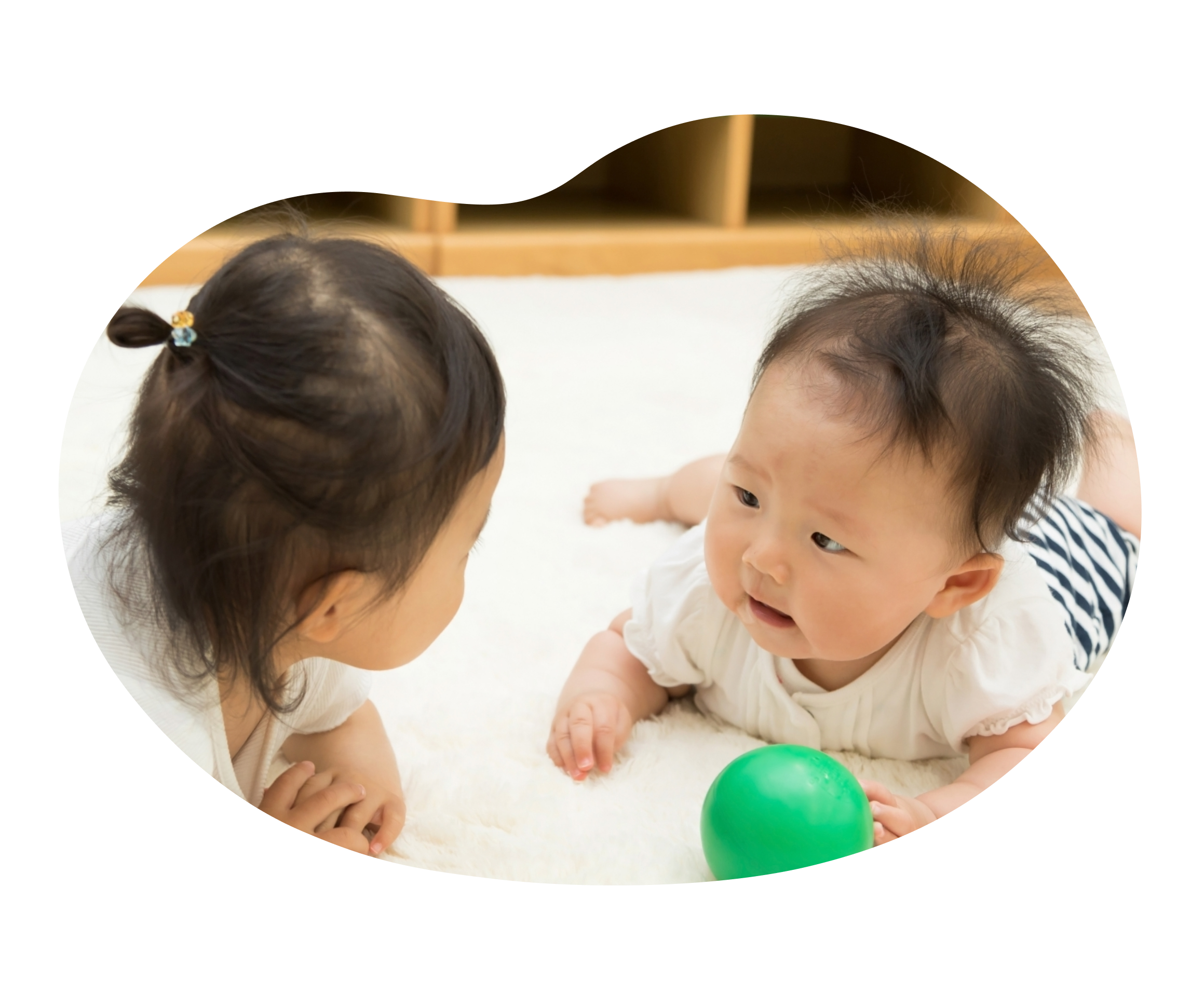 赤ちゃんと子どもがお互いを見つめ合う写真